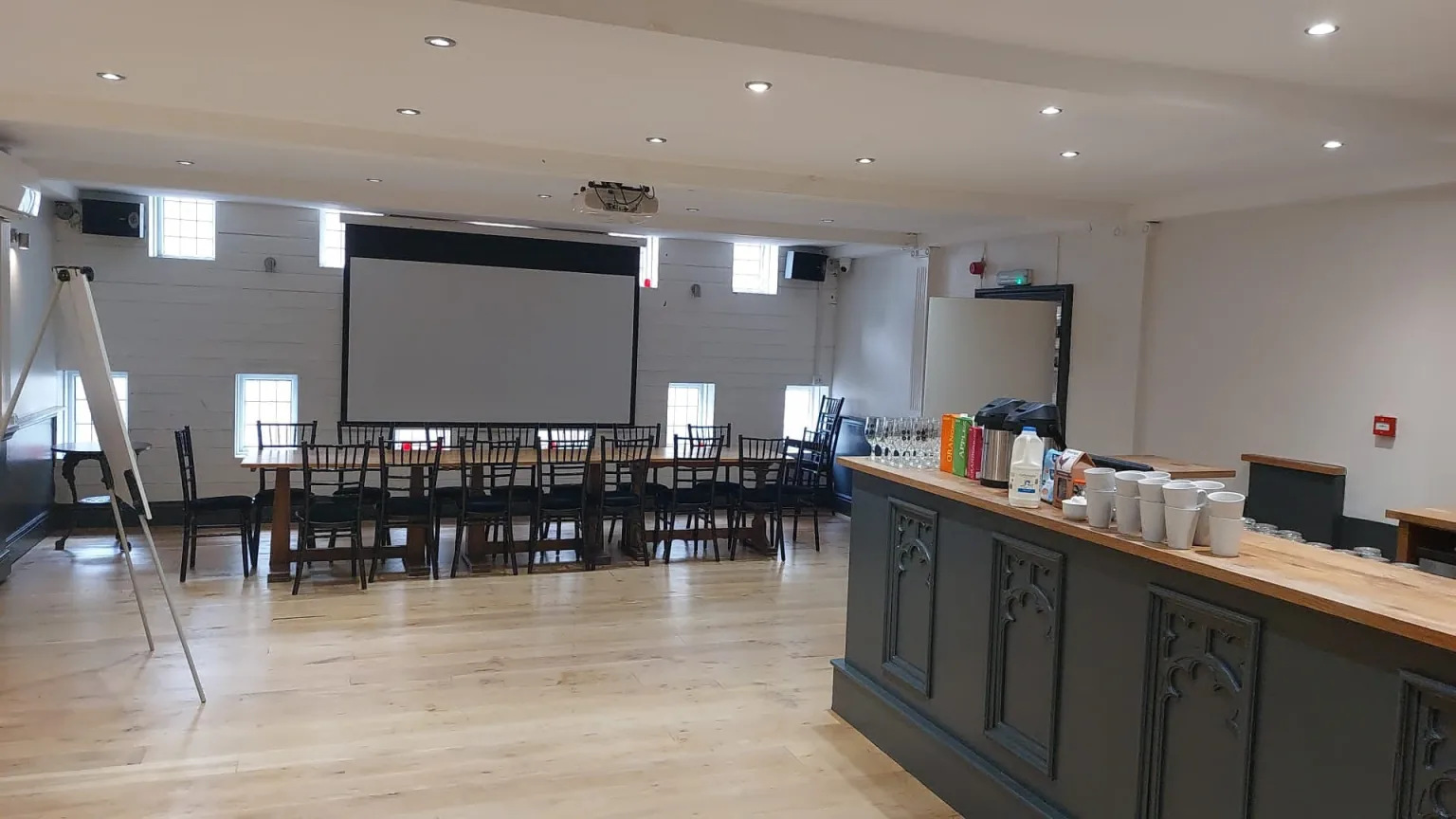 The Volley’s first-floor function room with black chairs, a projection screen and a private bar